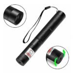 Green laser beam emitted from handheld device in dark setting showing focused bright output