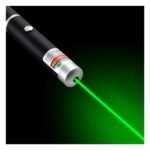 Green laser light beam emitted from handheld pen in dark environment showing bright focused output