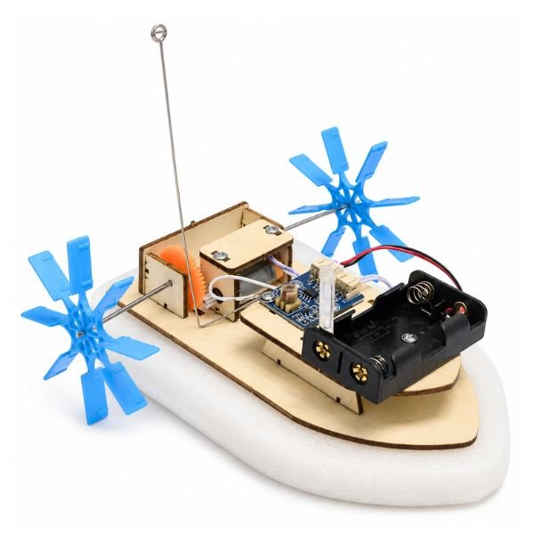 Remote Control DIY Paddle Wheel Boat Kit parts including wooden panels, motor, paddle wheels, and wiring components arranged on surface